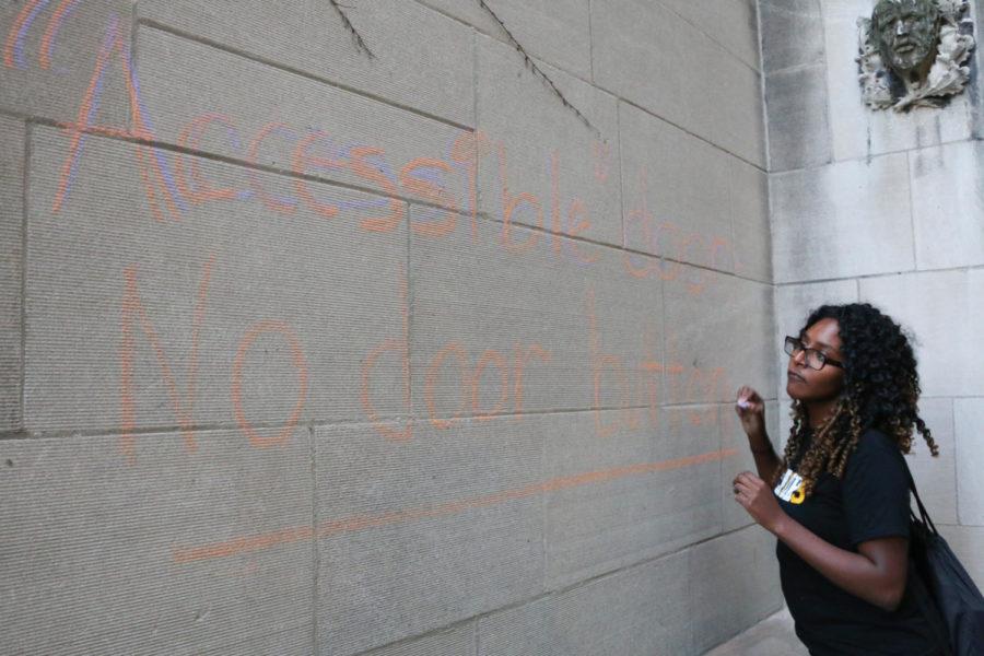 Mariam Desta works on chalking a wall with the message: “Accessible door—No door button” as part of a protest held a week ago.