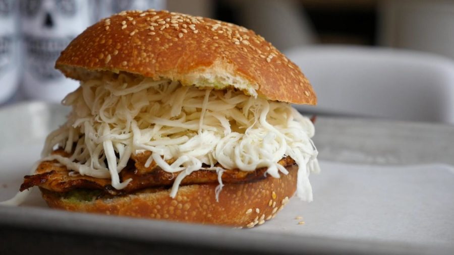 The cemita is served on sesame seed bread with Oaxacan cheese.