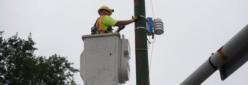 A worker installing one of the AoT sensors.