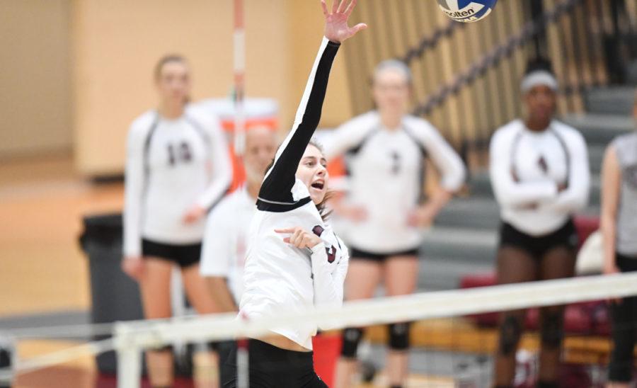 Second-year outside hitter Audrey Scrafford rises high above the net for to strike the ball.
