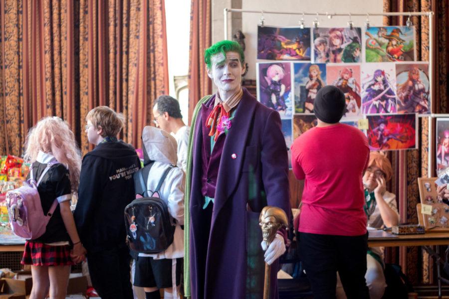 A Joker cosplayer sneers at the goings-on of the con. “Perhaps I’ll burn the place down,” he muses, “if I feel like it.”