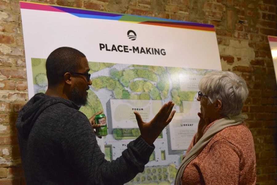 Two attendees review plans for the Obama Presidential Center.