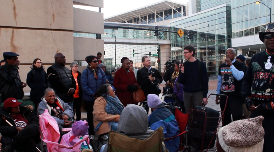 A UChicago Student speaks to community members at the prayer vigil against displacement outside the McCormick Center
