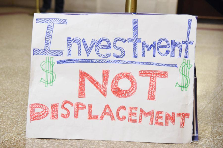 A sign left outside the city council chambers, reading Investment Not Displacement.