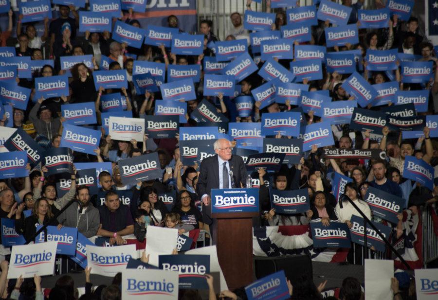 Sanders+supporters+at+a+rally+hold+Bernie+signs.