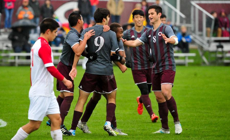 The mens soccer team celebrates the first goal of the game.
