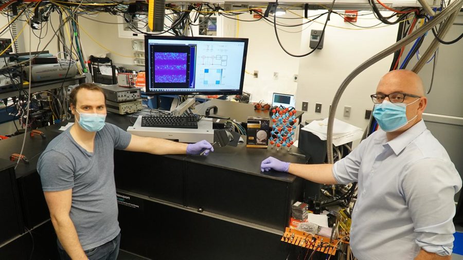 Researchers Alexandre Bourassa (left) and Chris Anderson (right) next to their quantum measurement instrumentation at the University of Chicago Pritzker School for Molecular Engineering.