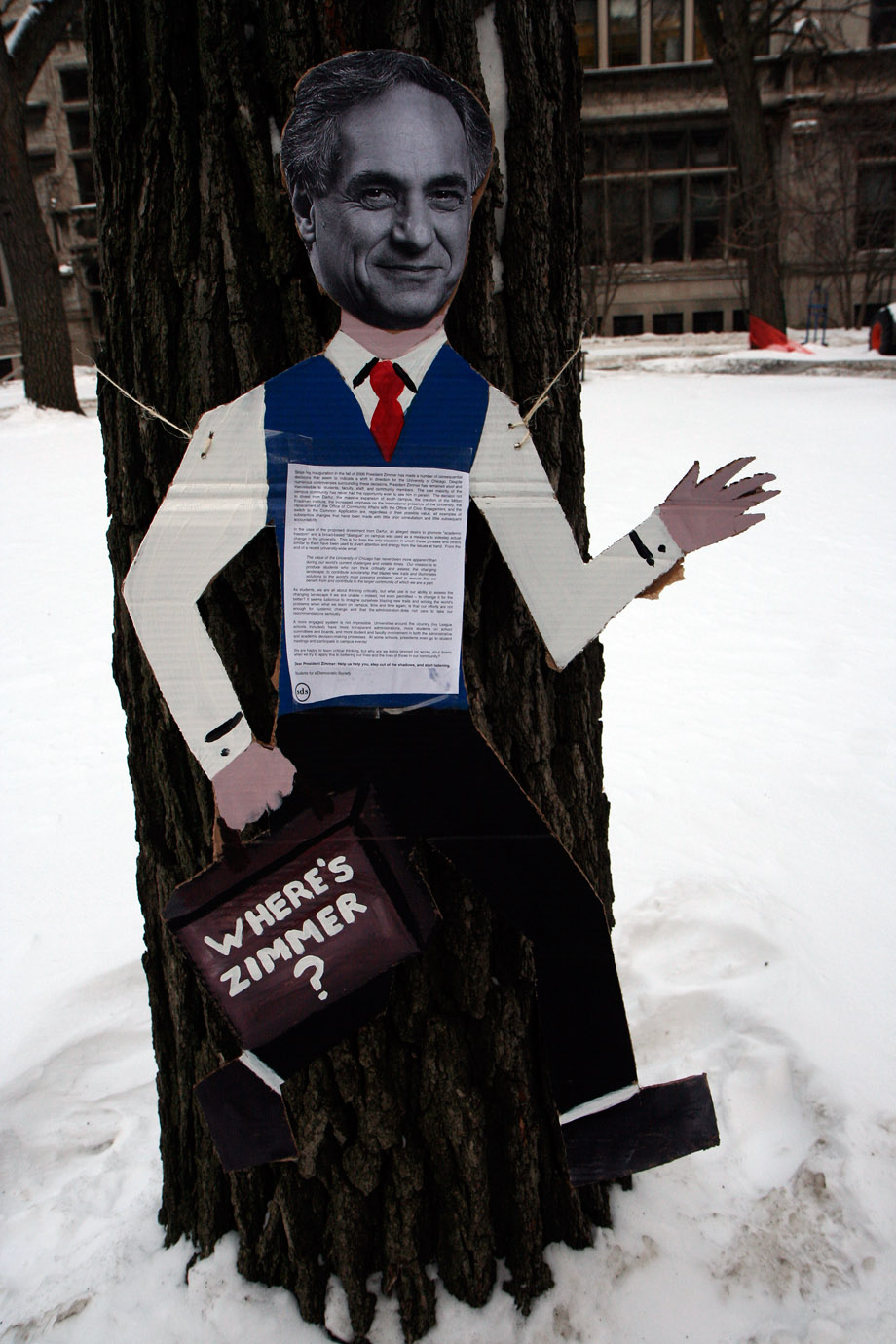 A caricature of University President Robert Zimmer waves to students passing Goodspeed on the main quads. In addition to carrying a briefcase with 