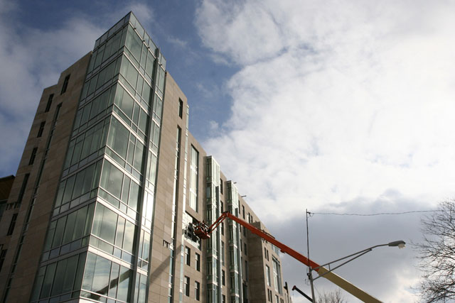 Construction workers work on a window at the new student dormitory at 61st and Ellis.