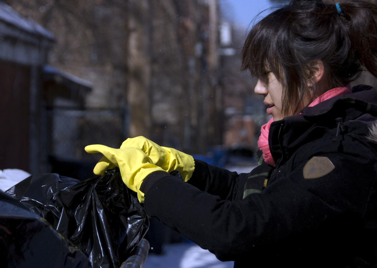 First-year, Tiffany Sommadossi reaches for a trash bag inside a dumpster.