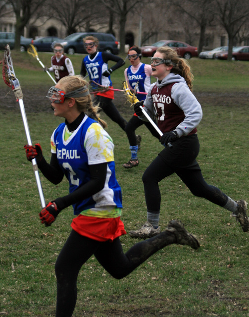 Marley Turner (foreground), third-year, and Kelly Varney (background), first-year, run along the Midway Plaisance during the women's lacrosse tournament held last Sunday.  The team won two of their three games that day.