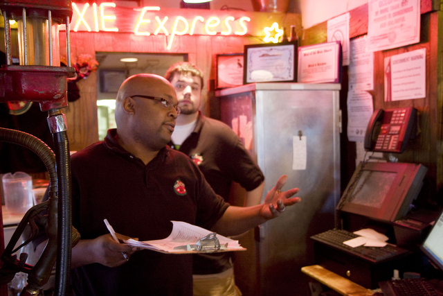 Manager Walter Butler (left) discusses table waits with a customer as Robert Kuth (right) looks on.  Waits are upward of two hours as the restaurant approaches its final day.