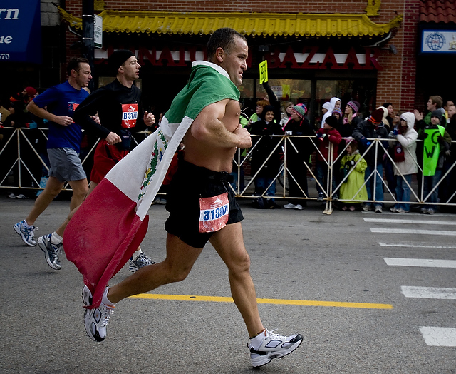 A marathon participant parading his national flag runs through Chinatown during the Chicago Marathon on October 11.