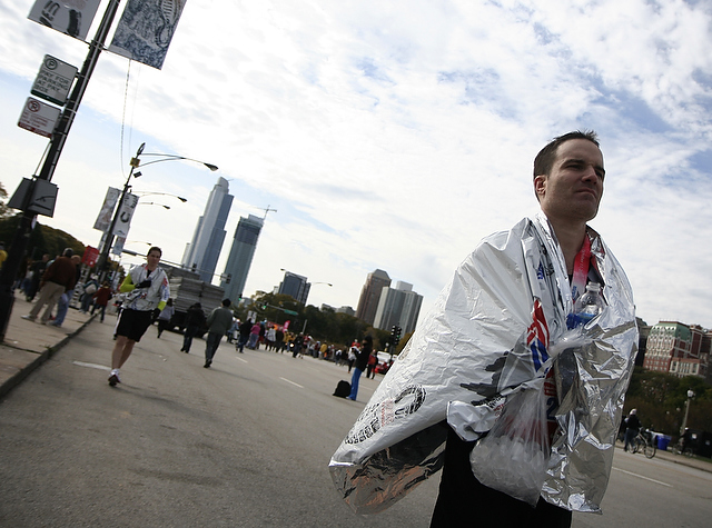 A marathon finisher re-heats himself with a space blanket. The Chicago Marathon took place on a cold and rainy Sunday. Runners completed a course that began and ended at Grant Park and wound all around the city.