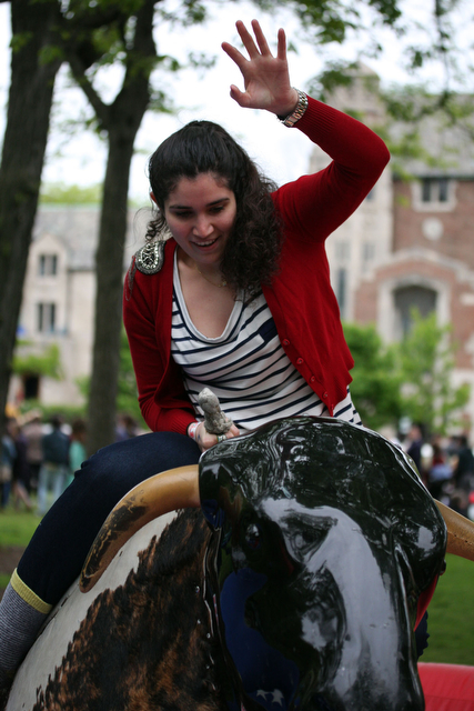 Fourth-year Nora Vallerini struggles to maintain her balance on the automated bull during the Summer Breeze Carnival.