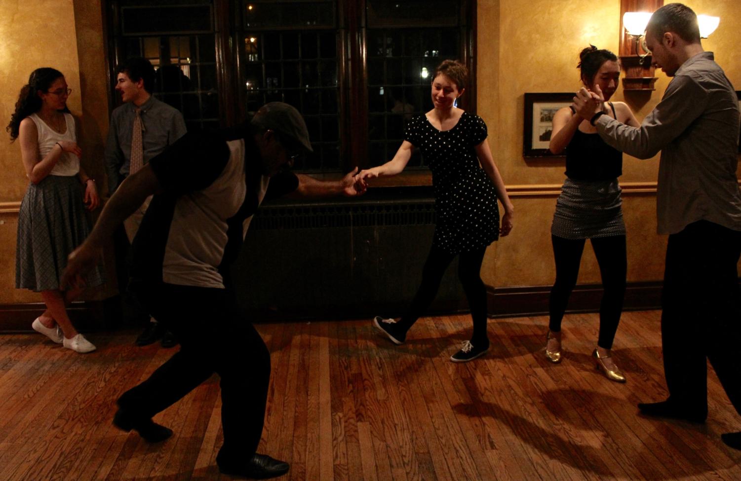Two dancers do the “swingout,” the signature move of Lindy Hop.