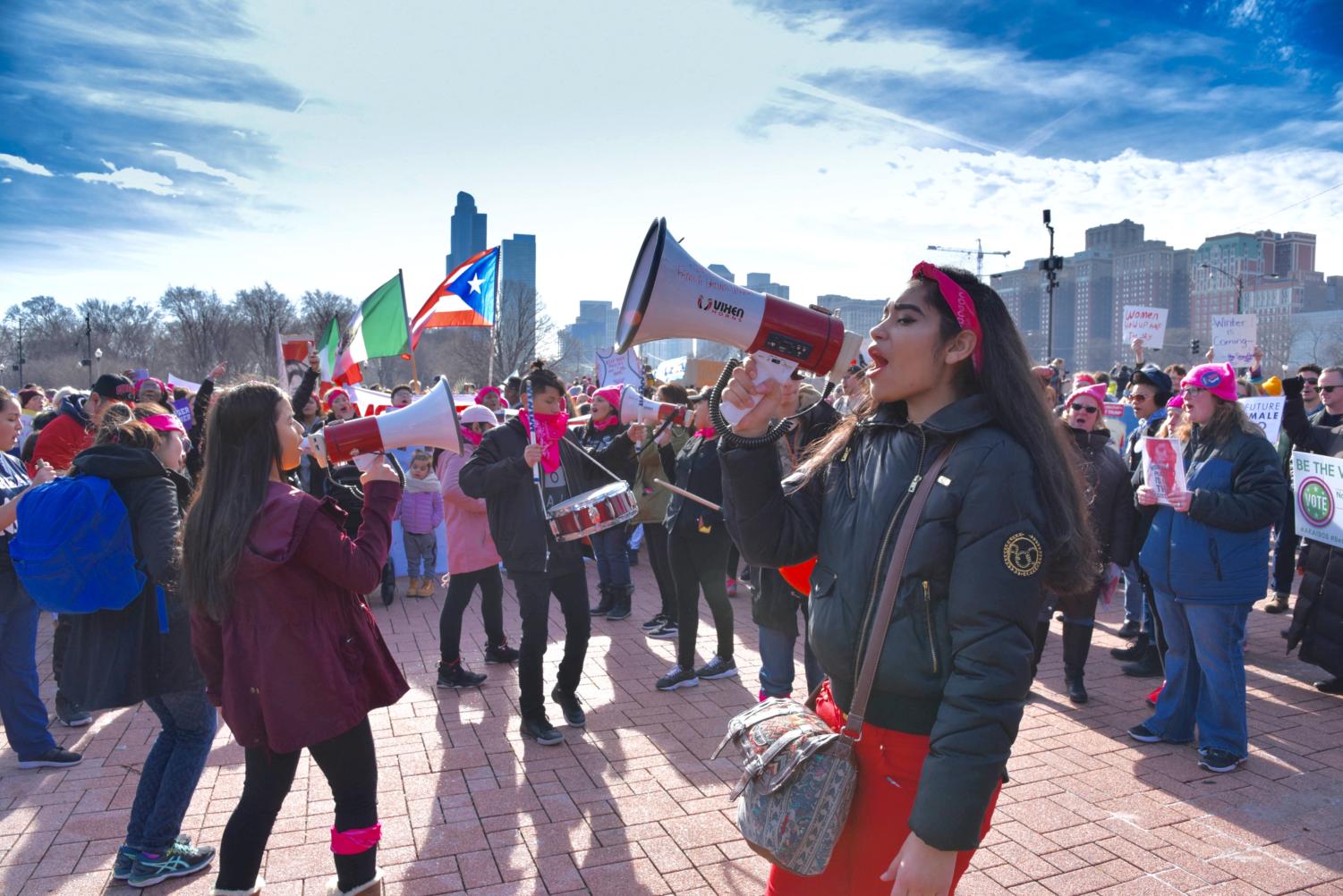 Marchers chant “no hate, no fear, immigrants are welcome here” while beating on drums and waving flags