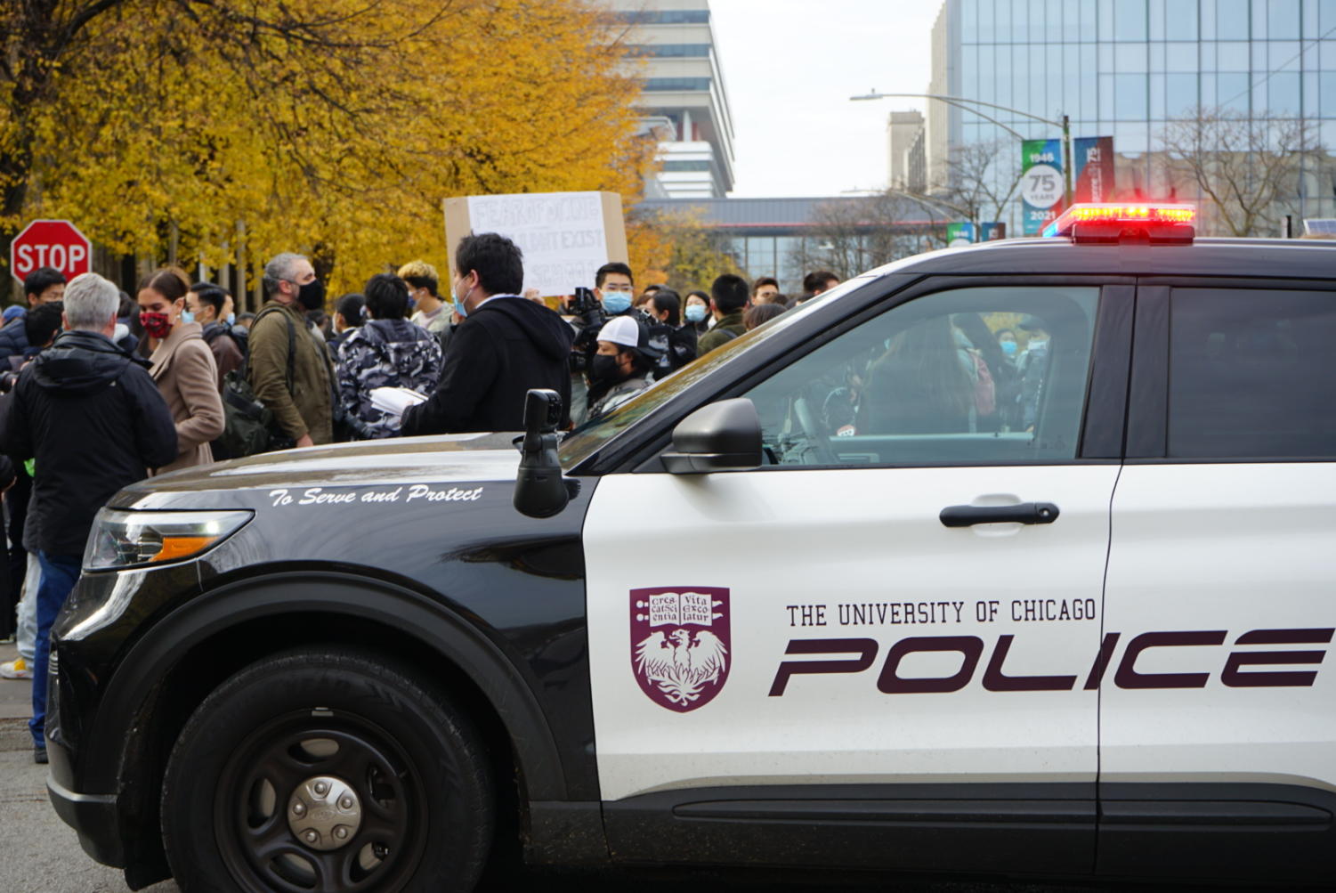 A UCPD car parked on 57th Street, temporarily blocking the traffic and leaving space for rally participants.