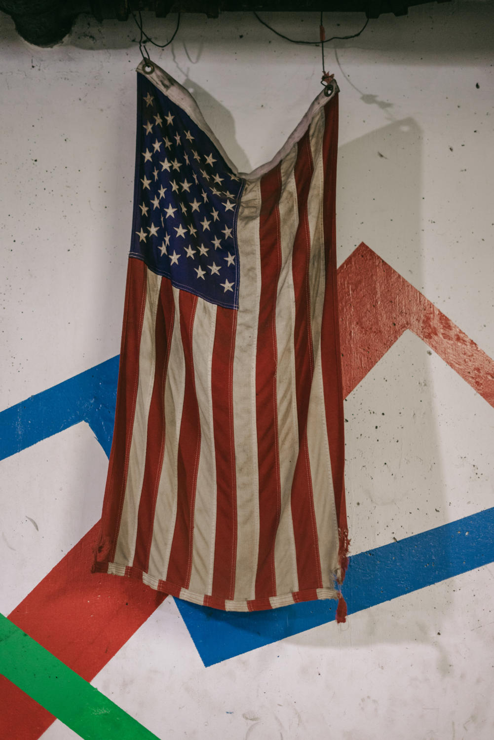 A tattered and smoke-blackened flag hanging in the underground gym