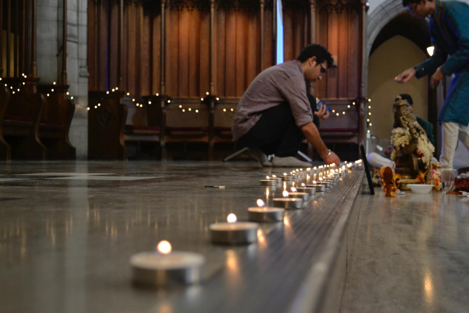 Students light candles in Rockefeller Chapel on the high chancel in preparation for the Diwali Puja.