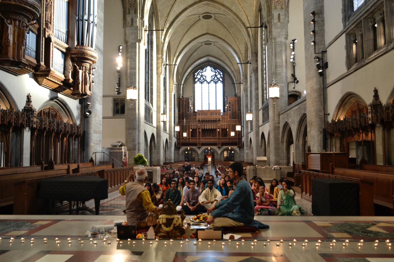 The audience sits on the chancel for the Puja.