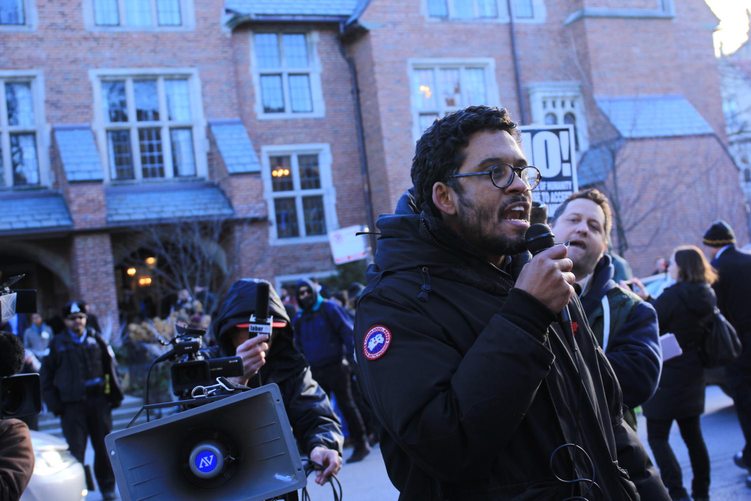 Anton Ford, a philosophy professor associated with UofC Resists, leads chants at an event featuring Corey Lewandowski.