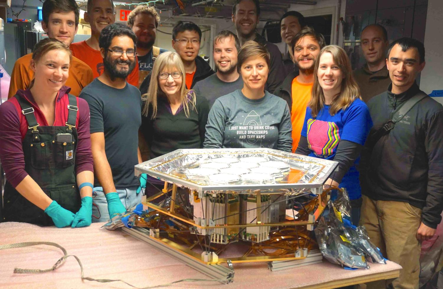 A picture of the team at the South Pole in front of the SPT-3G focal plane of microwave detectors.