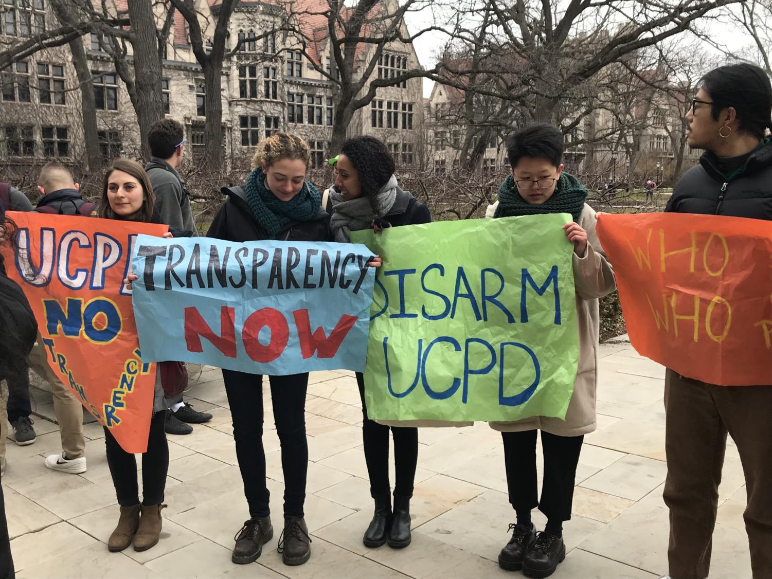 Student protesters hold signs reading 