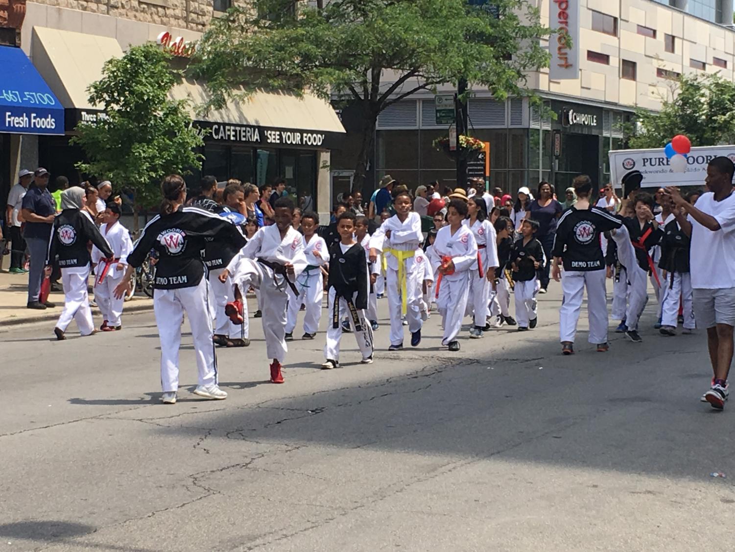 One of two contingents of martial arts students, the pupils at Pure Woori Taekwondo & Hapkido Academy took turns taking shots at punching bags as they marched.