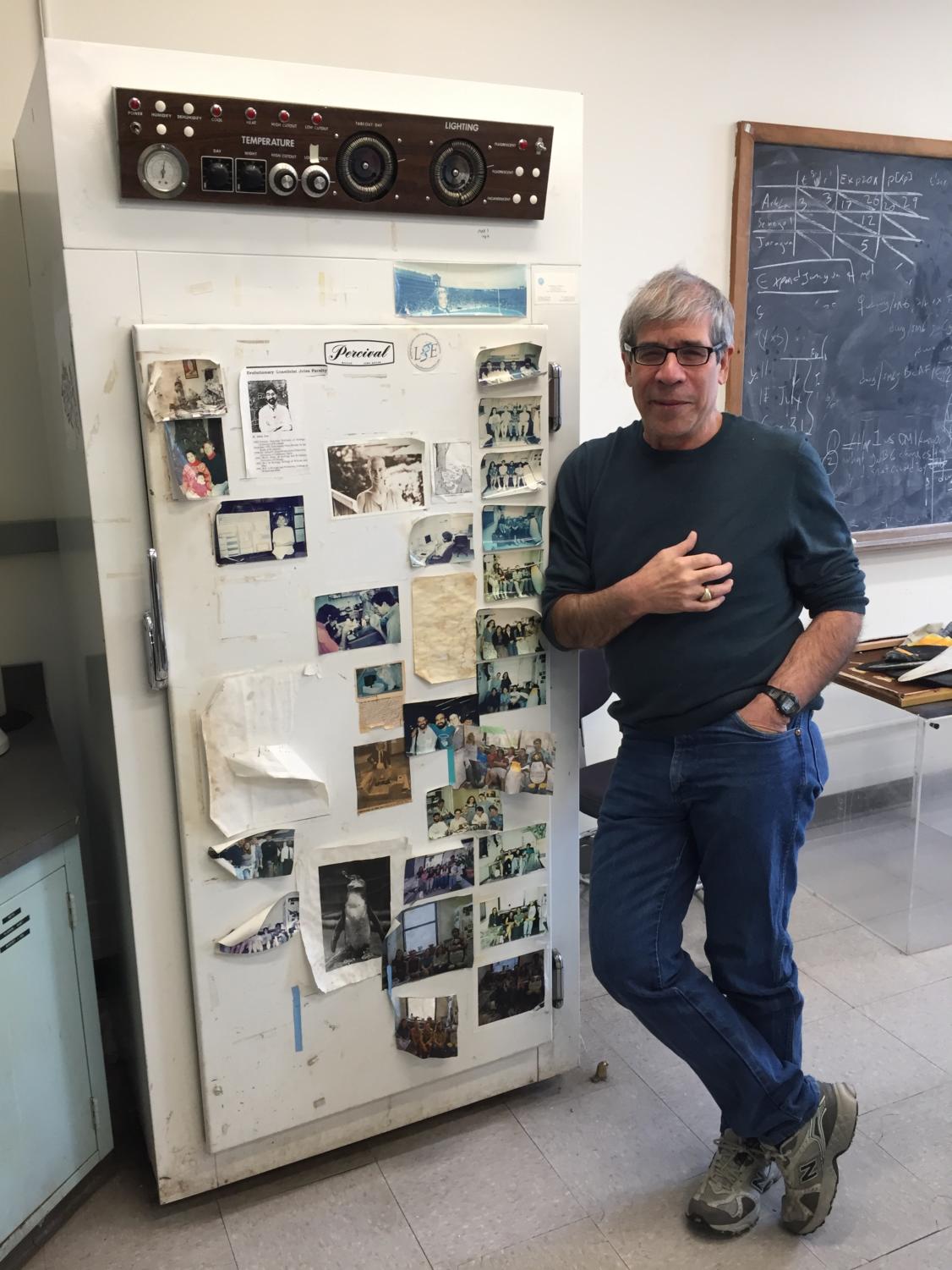 Coyne stands besides pictures of past lab teams taped to a now-empty incubator.