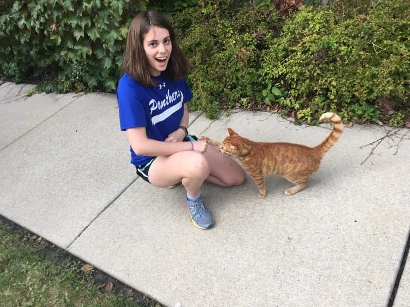 Devon Wenzel (left), who runs the @nestorthemidwaycat account, with Nestor (right).