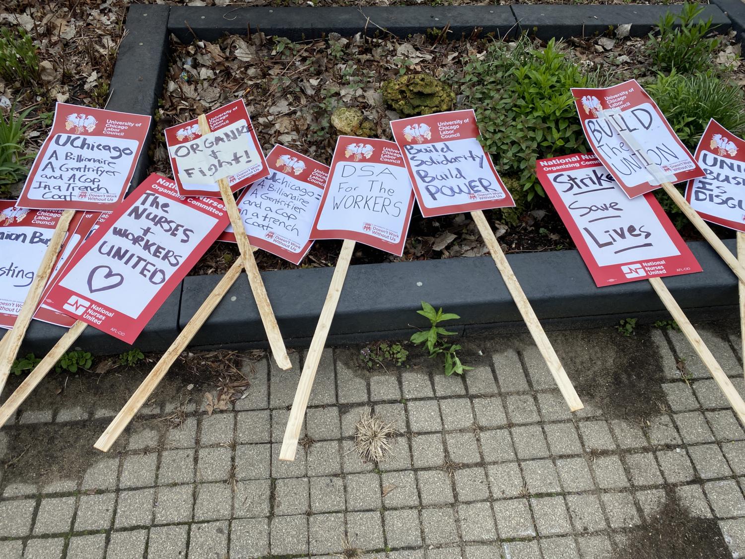 Posters laying on the ground in Nichols Park during the UChicago Labor Council's May Day commemoration event.