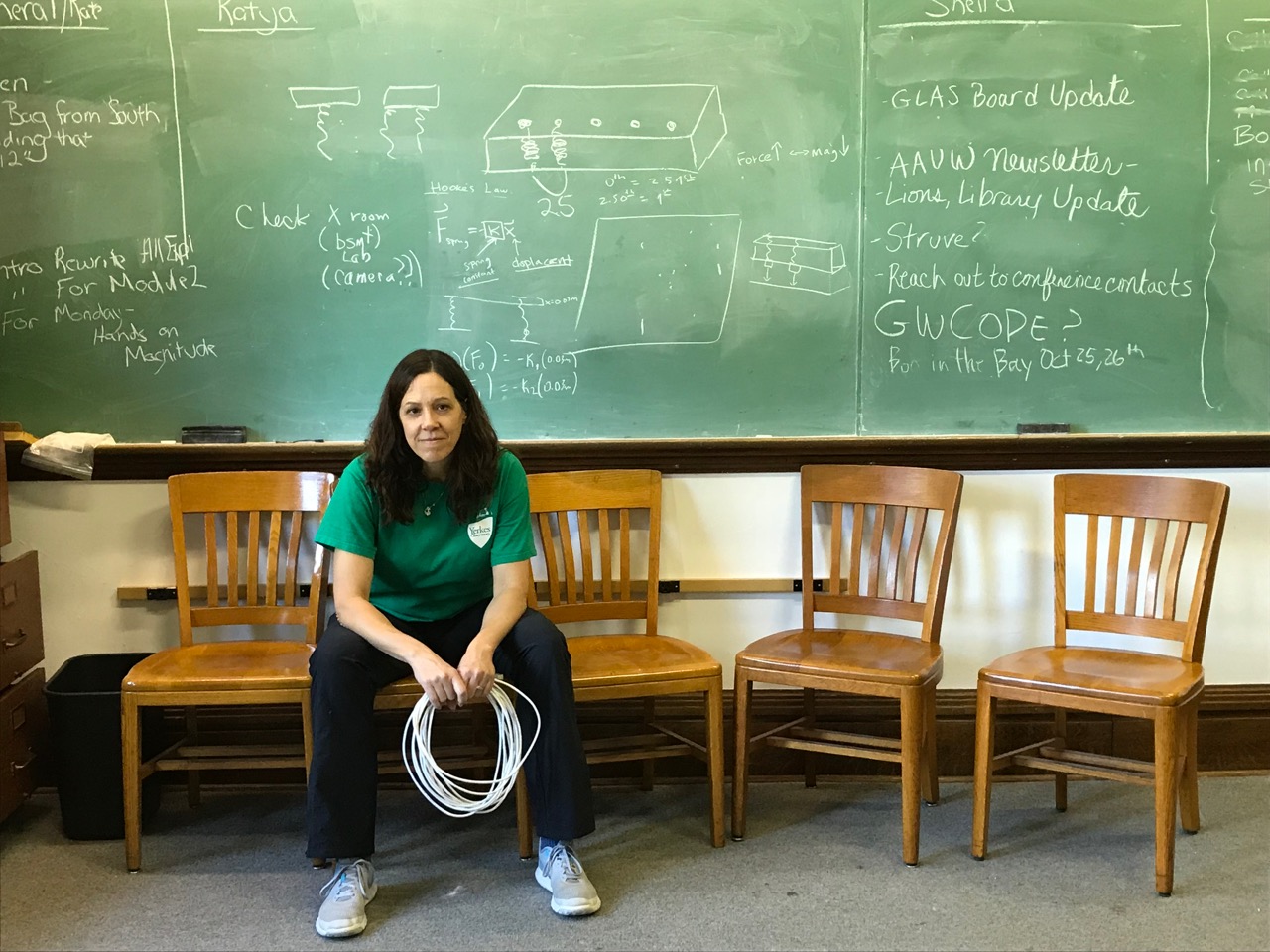 Kate Meredith, the former director of YEO, sits in front of a blackboard.