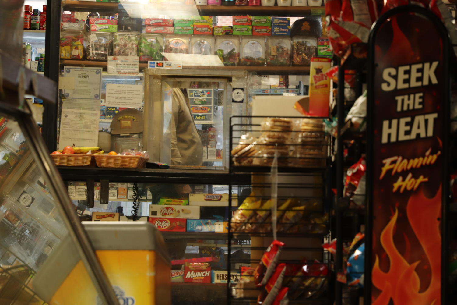 Store-owner Kanan Ashkar stands behind the bullet-proof glass through which customers make payments.