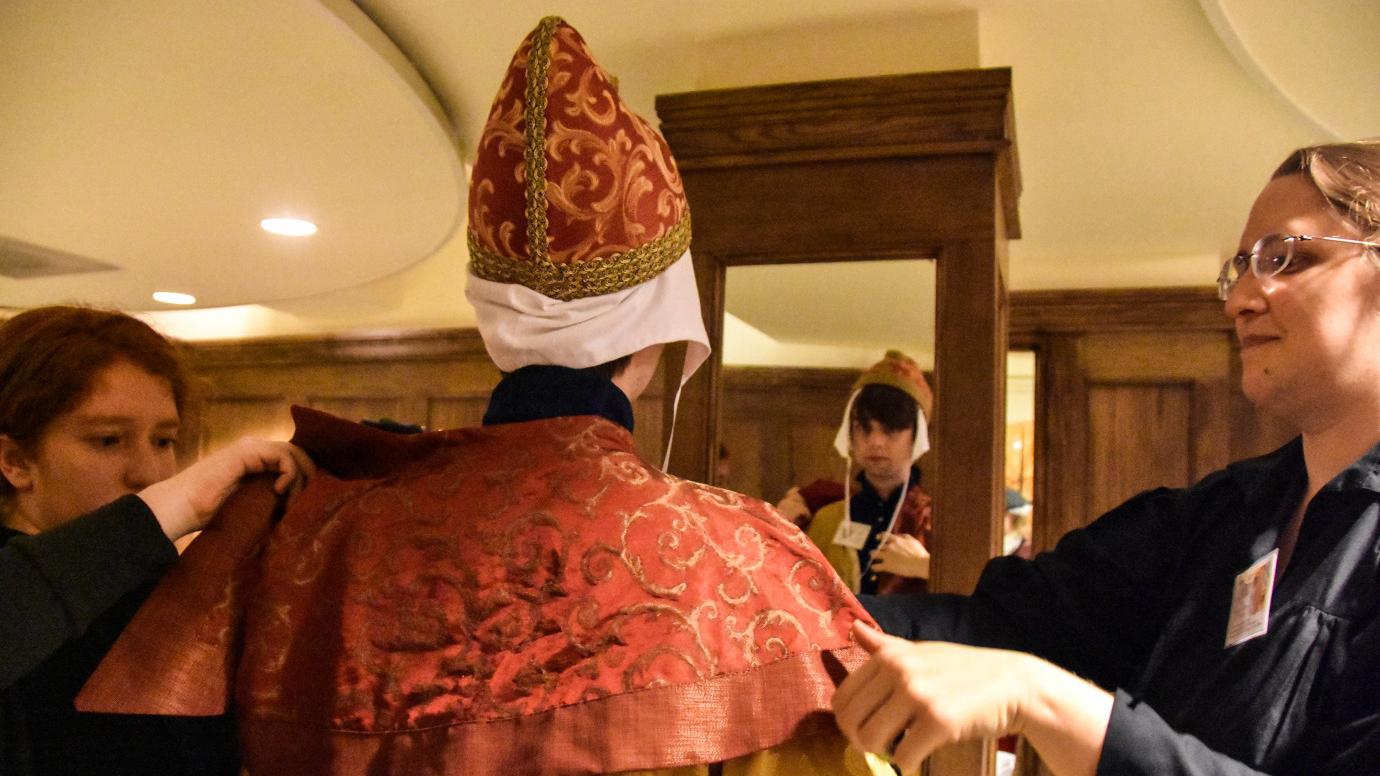 Palmer, right, helps a student into costume at her famous reenacted papal election.