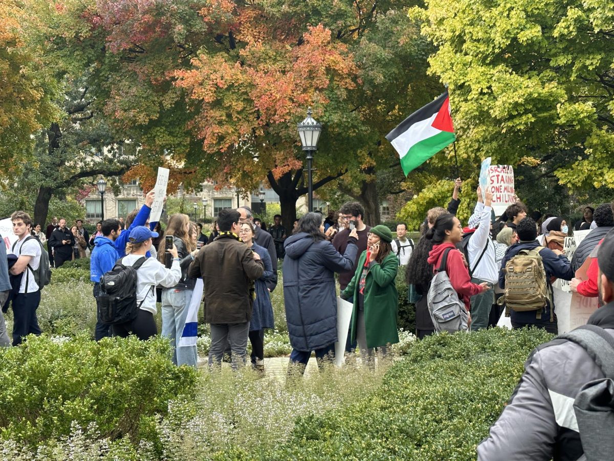 Protestors from Maroons for Israel and SJP are separated by a Dean-on-Call during rallies on the quad.