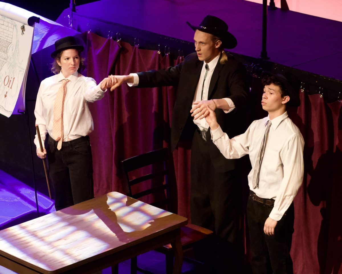 Henchmen Astoria (Maisie Thompson) and Hilton (Jacob Halabe) join hands with oil baron Dallas (Robert Stimpson). Credit Coco Liu and University Theater.