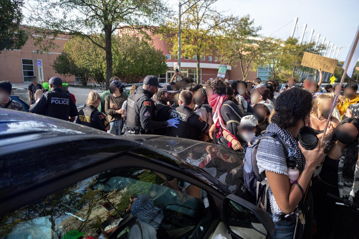 UCPD officers and protesters surround a police car where a protester had been detained.