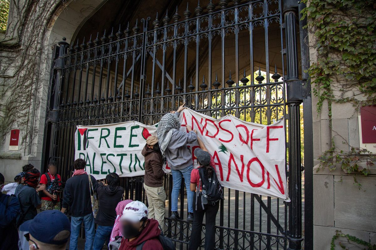 After locking Cobb Gate, protesters hang a banner reading “Free Palestine” and “Hands Off Lebanon.” 
