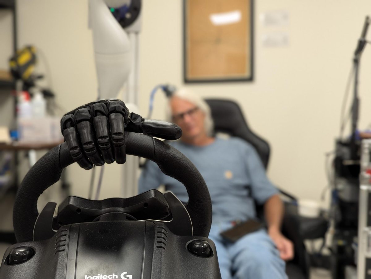 Participant operating bionic arm in a driving wheel simulation.