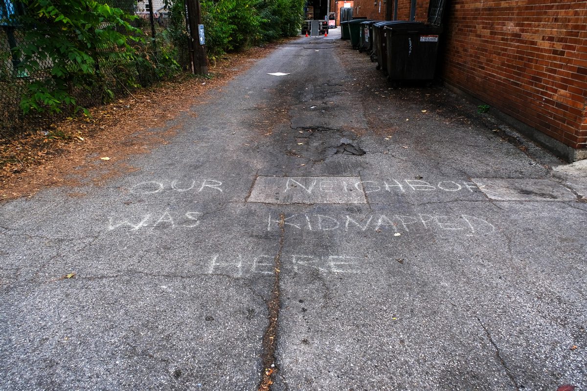 A chalked message reading "Our neighbor was kidnapped here" near an immigration enforcement sighting and detention at E. 52nd Street and S. Kimbark Ave.