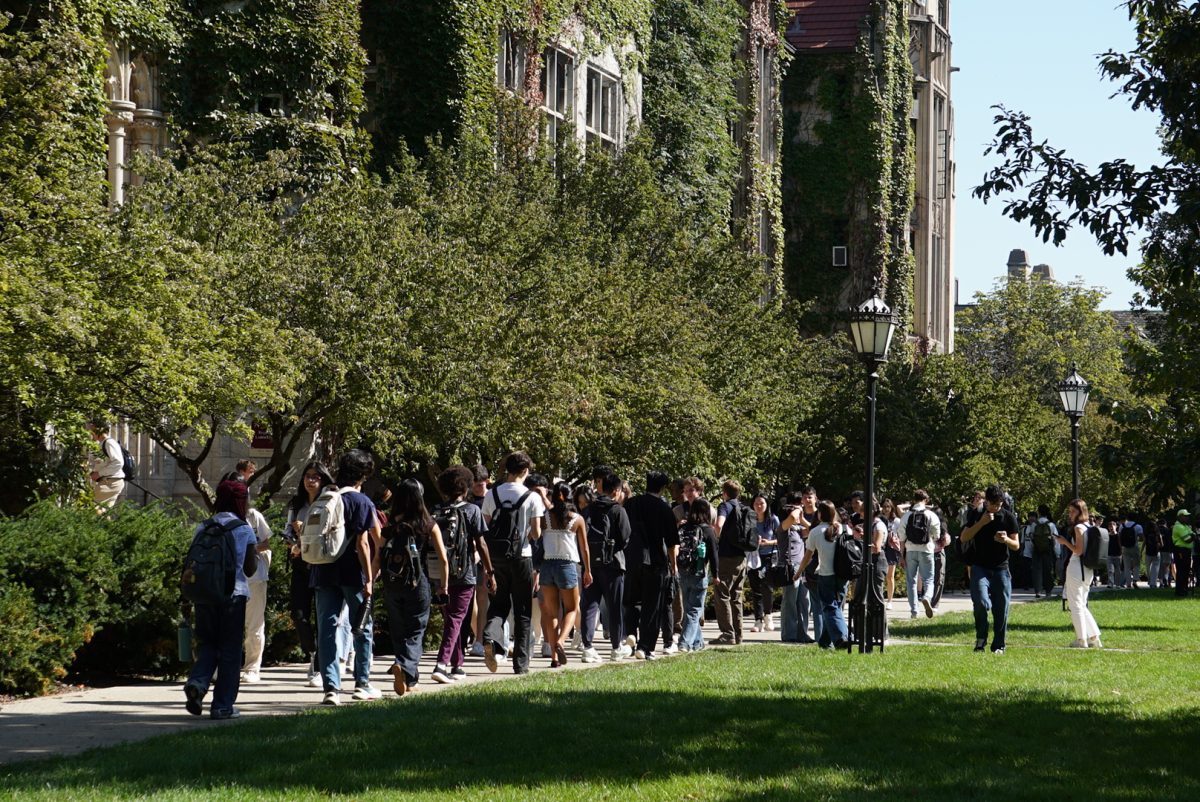 A group of students walks in front of Ryerson Physical Laboratory.