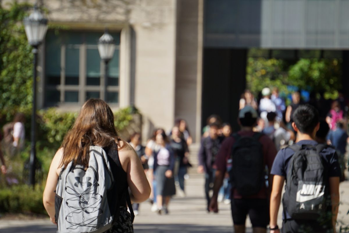 Students walk across the main quad toward Edward H. Levi Hall.