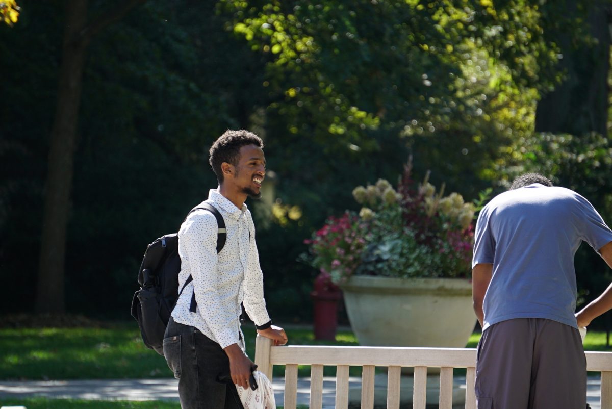 A student speaks to another student on the main quad.