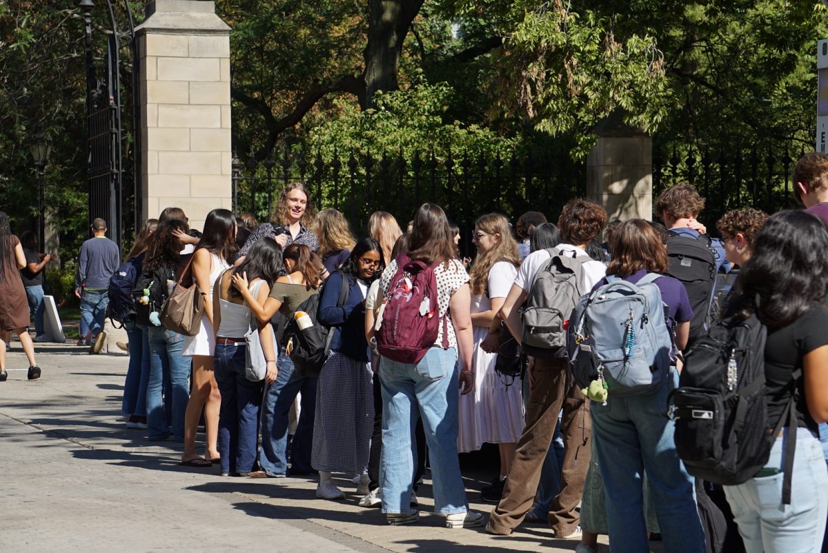 A large group of students line up to take their first-day-of-class photo in front of Hull Gate.
