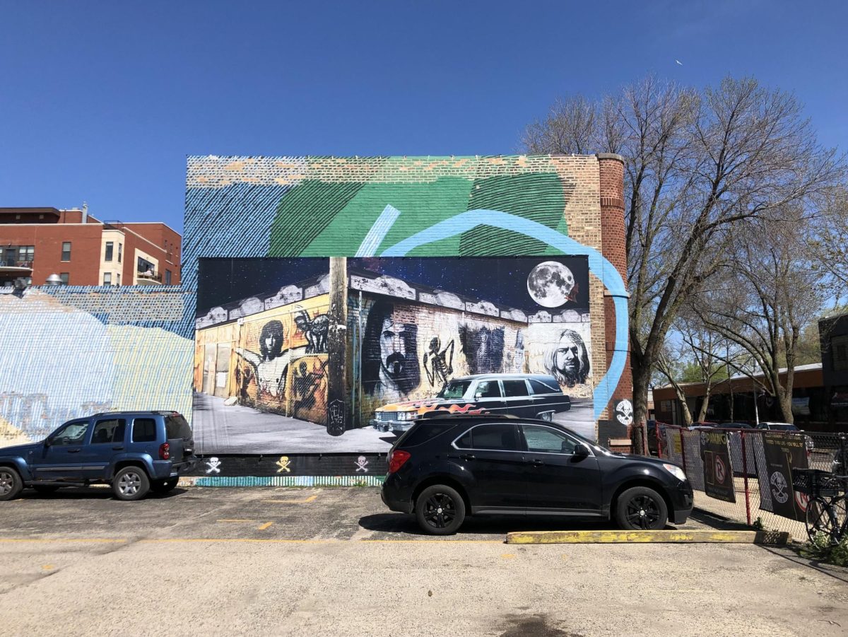 Mural on The Alley’s side depicting the surroundings of the original store at Belmont and Clark and one of Mark Thomas’s hearses parked nearby. 
