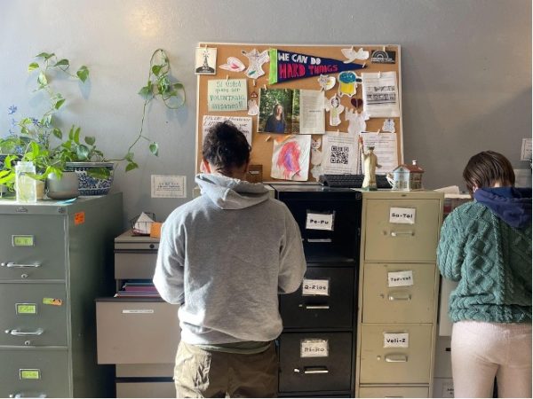Volunteers at the legal aid clinic work in front of a bulletin board with a pennant reading “We can do hard things.” Graves asked that the South Side religious institution where the clinic operates remain unnamed because of the vulnerable legal status of her clients.