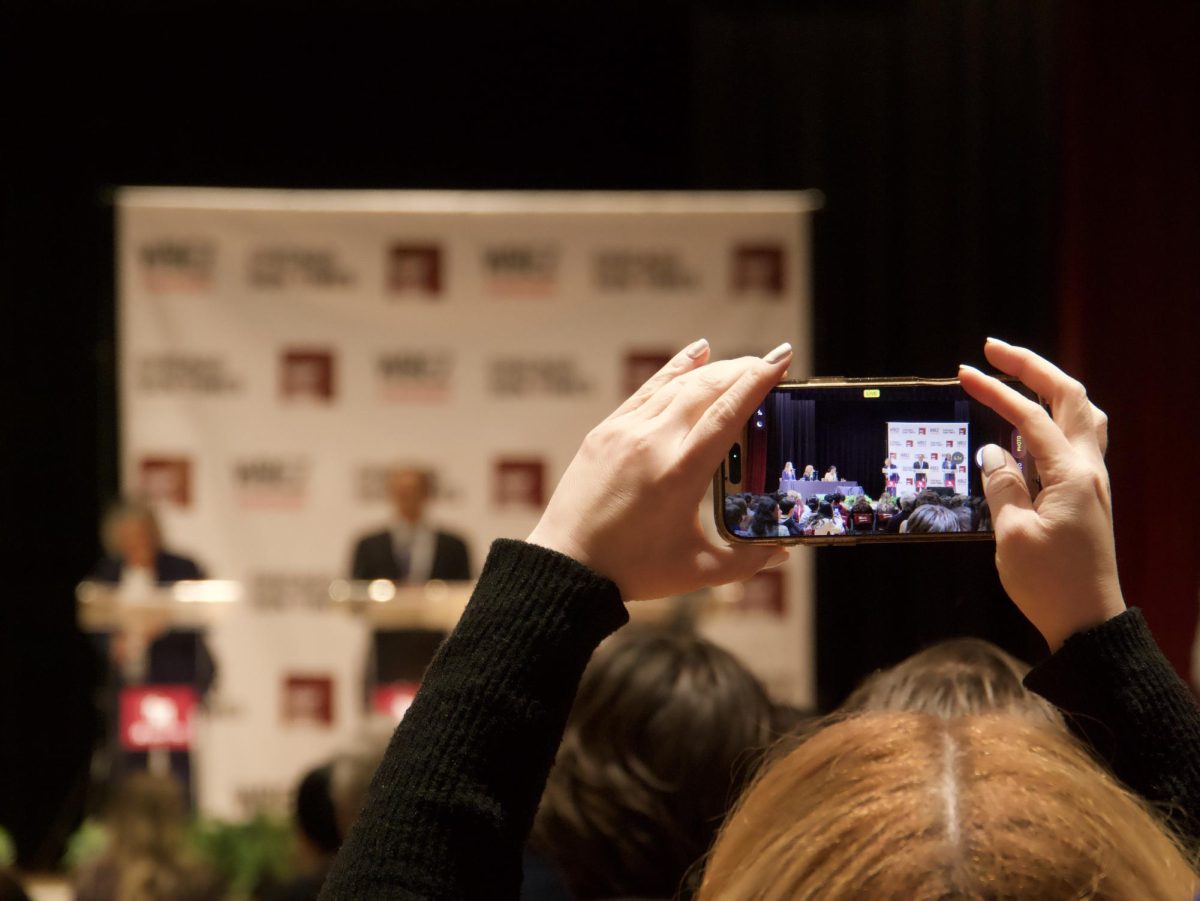 An audience member takes photos during the debate. 