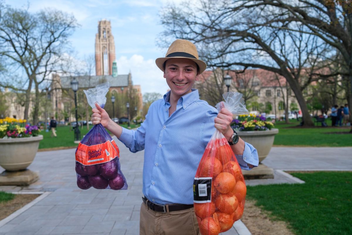 Second-year Adam Ash holds two bags of onions in the main quad.