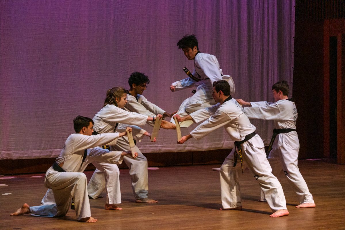 Fourth-year Anderson Hu, one of UChicago Taekwondo’s Co-Captains, performs a flying kick, breaking five wooden boards midair.